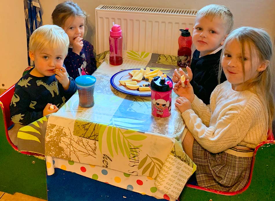 Villa Regenwürmchen - vier Kinder am Küchentisch essen Obst